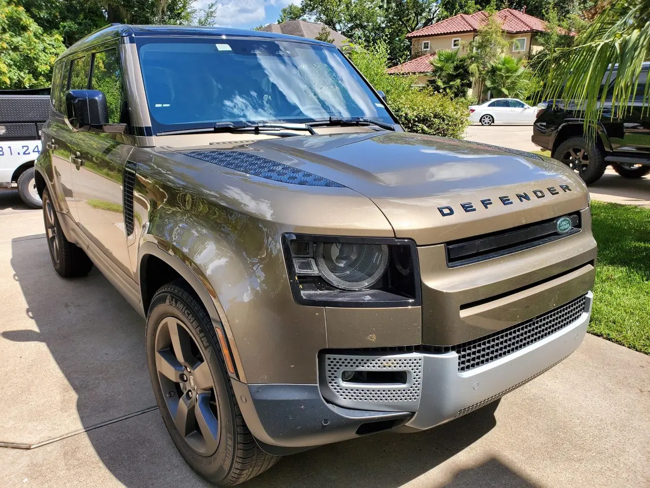 A tan land rover parked in the driveway.