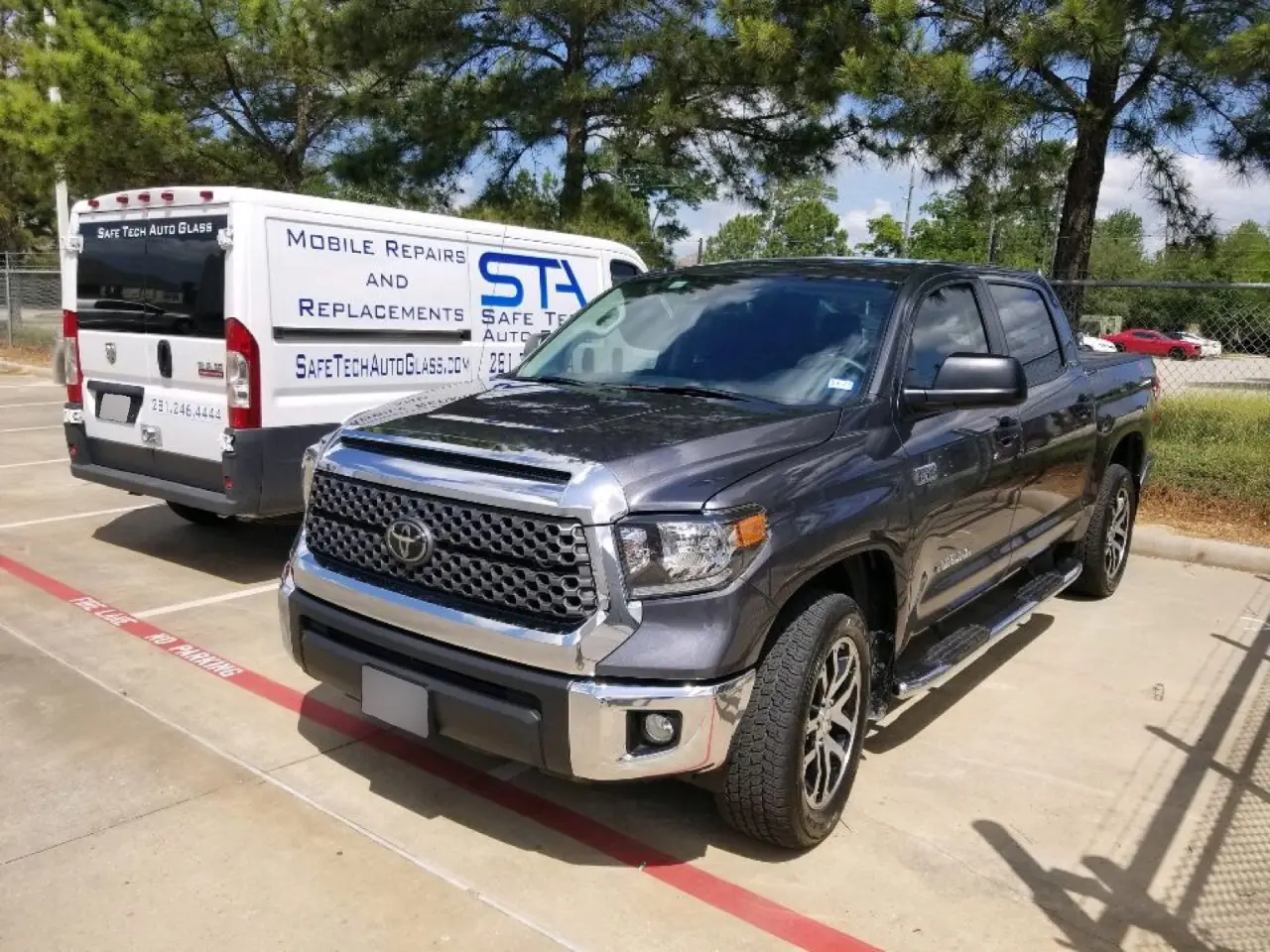 A truck parked in the parking lot next to another vehicle.